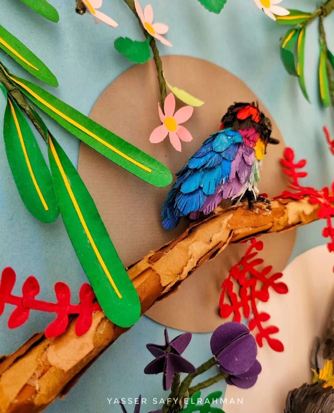 Colorful garden birdwatch artwork by Yasser Safy Elrahman featuring various birds perched in a lush garden scene.
